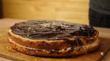 Pastayı çikolata ve fındıkla süslüyorsun. Evde şenlikli turta pişiriyorum. Yavaş çekim.