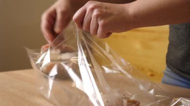 Tavuk pişirmek için bir torbaya (kol) konur. Yavaş çekim.