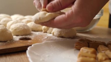 Donut yapmak için, şekerlemeler hamura eklenir. Çörek yapma süreci. Yavaş çekim.