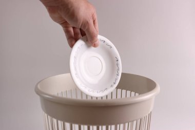 Plastik bir tabak geri dönüşüm için çöpe atılır.