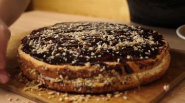 Pastayı çikolata ve fındıkla süslüyorsun. Evde şenlikli turta pişiriyorum.