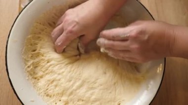 Bir kadın çörek yapmak için hamur parçaları oluşturur. Çörek yapma süreci.