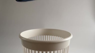 Eski bir örgü şapka çöpe atılır. Yavaş çekim.