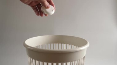 Diş ipinden çıkan ambalajlar çöpe atılıyor. Yavaş çekim.