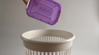 Plastik bir market konteynırı geri dönüşüm için çöpe atılır. Yavaş çekim.