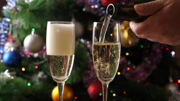 Vor Dem Hintergrund Eines Weihnachtsbaums Mit Funkelnden Girlanden Wird Champagner — Stockvideo