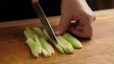 Taze salatalık yemek pişirmek için parçalara ayrılır. Salatalık pişiriyorum.