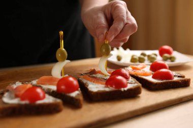Sandviçe zeytin ve soğan eklenir. Balık ve sebzeli kanepelerin hazırlanması