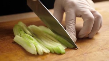 Taze salatalık yemek pişirmek için parçalara ayrılır. Salatalık pişiriyorum.