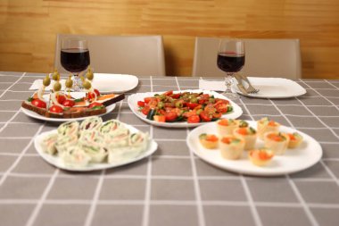 Kırmızı şarap, şenlik yemekleriyle dolu bir masada bir bardağa doldurulur.