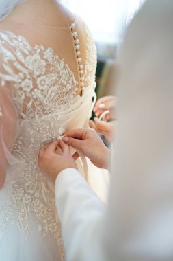 Kız arkadaşlar gelinin gelinliği bağlamasına yardım eder. Düğün hazırlıkları..