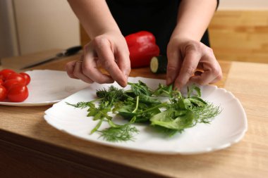 Yeşillikleri bir tabağa koy. Sebze salatası hazırlığı