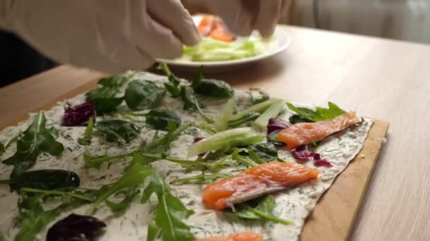 将鲑鱼和黄瓜加入芝士和青菜的洗发水中 用奶酪 鱼和蔬菜准备一个面包卷 慢动作 — 图库视频影像