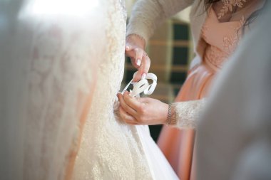 Kız arkadaşlar gelinin gelinliği bağlamasına yardım eder. Düğün hazırlıkları..