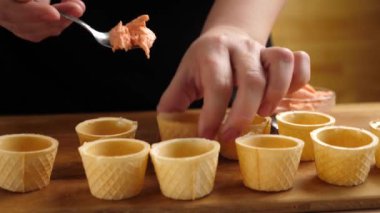 Fırında waffle sepetleri balık ezmesiyle doludur. Kanapelerin hazırlanması. Yavaş çekim.