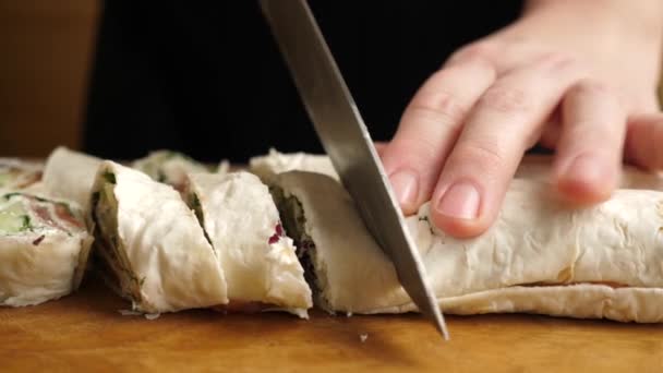 用刀把皮塔卷切碎 用奶酪 鱼和蔬菜准备一个面包卷 慢动作 — 图库视频影像