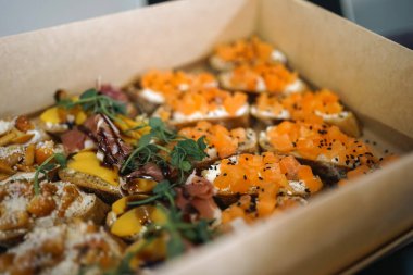 Soğuk atıştırmalıklar, sandviçler, jambon ve somon karton bir kutuda teslim edilir..