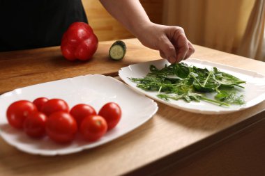 Yeşillikleri bir tabağa koy. Sebze salatası hazırlığı