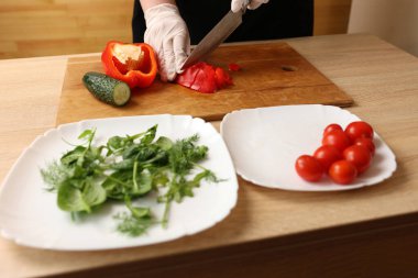 Kırmızı biber, sebze salatası hazırlamak için bıçakla kesilir. Sebze salatası hazırlığı
