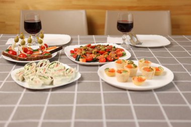 Kırmızı şarap, şenlik yemekleriyle dolu bir masada bir bardağa doldurulur.