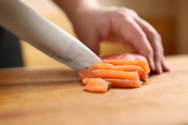 Kırmızı balık tahtanın üzerinde bir bıçakla parçalara ayrılır..