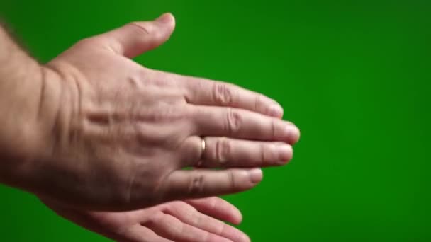 男は緑の背景に手をぶら下げる — ストック動画