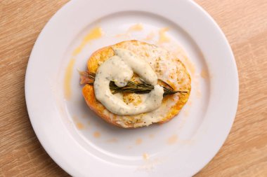 Taze pişmiş somon bir tabağa konur ve sos eklenir.