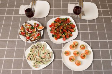 Festival masasında rulo, sebze salatası, kanepe ve kırmızı şarap servis edildi..