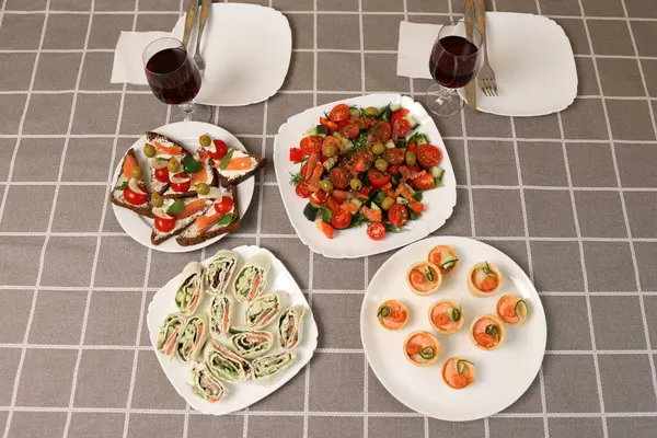 Festival masasında rulo, sebze salatası, kanepe ve kırmızı şarap servis edildi..