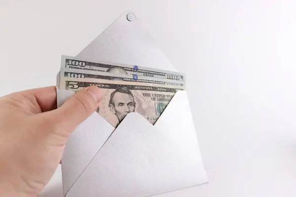 Dollar bills are taken out of the envelope. The concept of premium, payment, bribe.