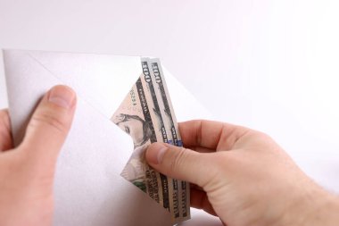 Dolar banknotları zarftan çıkarılıyor. Prim, ödeme, rüşvet kavramı.