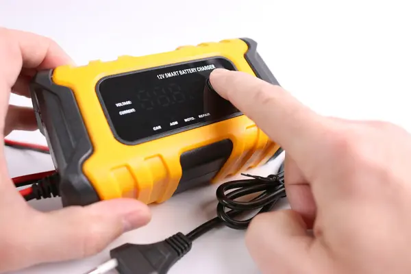 A man gets acquainted with the functions and capabilities of a multi-functional charger.