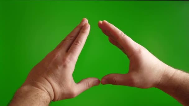 人間の手は緑の背景に心臓のジェスチャーを示します — ストック動画