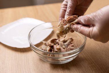 Haşlanmış tavuk eti kemiklerden ayrılır. Tavuk yemeği pişiriyorum..