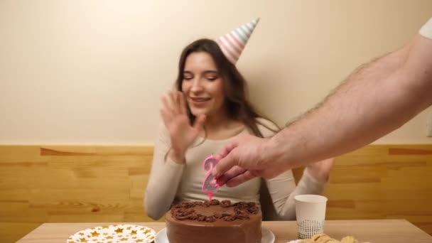 女の子がテーブルの前に座り 26という数字の形をしたろうそくが立ち往生する 誕生日のお祝いのコンセプト — ストック動画