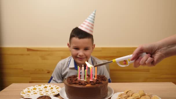 Băiatul Stă Fața Unei Mese Tort Festiv Lumânări Suflă Afară — Videoclip de stoc
