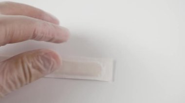 Paketten ahşap bir tıbbi spatula çıkarılıyor. Steril spatula.