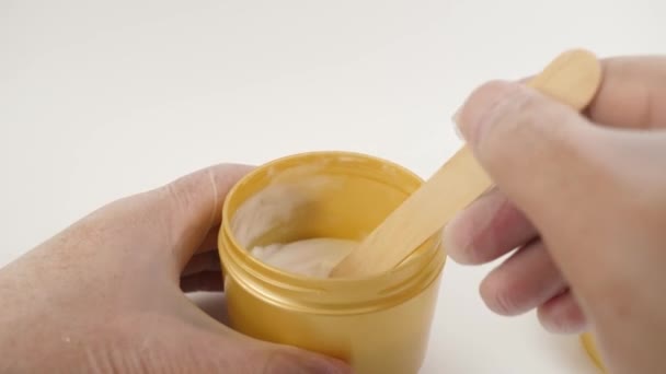 塑料罐子里的化妆品凝胶被涂在木制铲斗上 — 图库视频影像