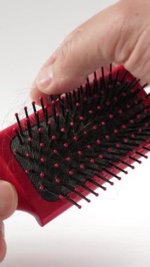 Saçım tarağa takıldı. Saç problemi konsepti. Kırılgan ve dağınık saçlar. Alopecia. Dikey video