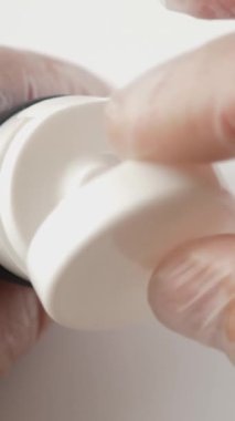 Küçük bir miktar krema spatulaya sıkışıyor. Kozmetik kavramı. Dikey video