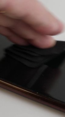 Akıllı telefon ekranı bir peçeteyle silinmiş. Akıllı telefon bakımı. Dikey video