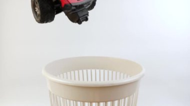 Bozuk bir çocuğun oyuncak arabası çöp kutusuna atılır. Plastiklerin geri dönüşümü. Yavaş çekim
