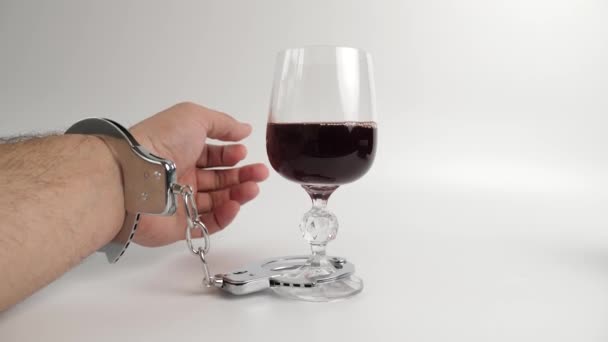 手錠の男はワインのグラスと組み合わされています アルコール依存症の概念 — ストック動画