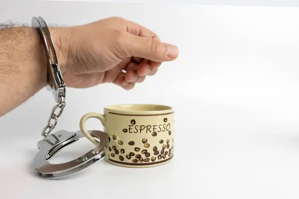 手錠の男がコーヒーを一杯飲んでいる コーヒー中毒の概念 ストックフォト