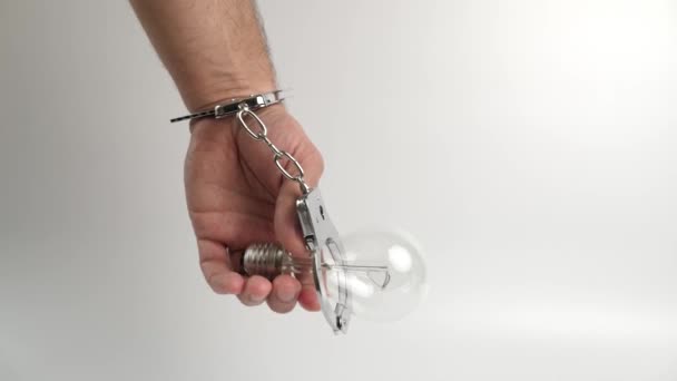 戴手铐的人与电灯泡相连 能源依赖的概念 — 图库视频影像