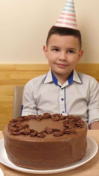 Chłopiec Siedzi Przed Stołem Tortem Urodzinowym Który Wbija Się Świeca — Wideo stockowe