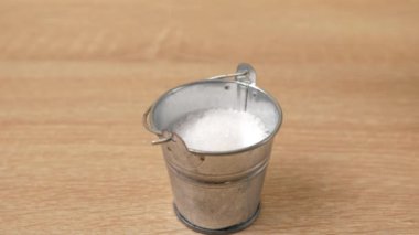 Tuz küçük bir metal kovaya dökülür. Tuz suistimali.