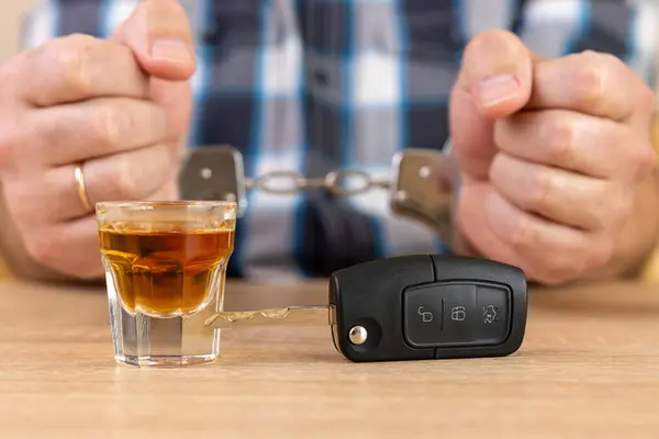 stock image A glass of alcohol and car keys. The concept of driving under the influence of alcohol.