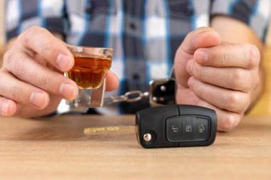 A glass of alcohol and car keys. The concept of driving under the influence of alcohol. clipart