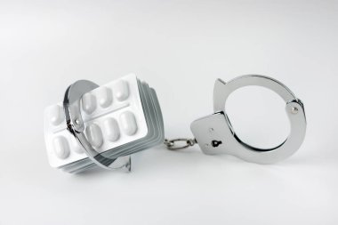 Kelepçe ve hap paketi. Uyuşturucu bağımlılığı kavramı. Bağımlılık.